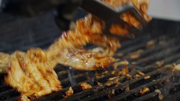 Close up of chicken breast roasted on a grill with flames