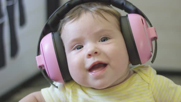 Slow Motion of Happy Baby Wearing Headphones alt
