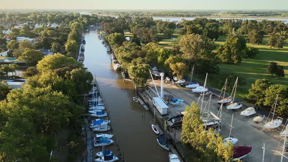 Aerial parallax shot rising over canals in San Isidro city in Buenos Aires at golden hour alt