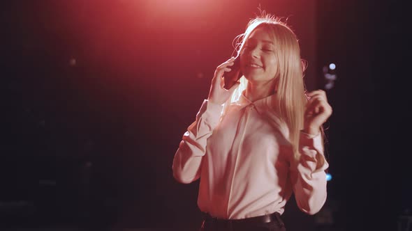 a beautiful girl talks on the phone and laughs. Beautiful lighting.Cute Sexy Blonde.Slow Motion