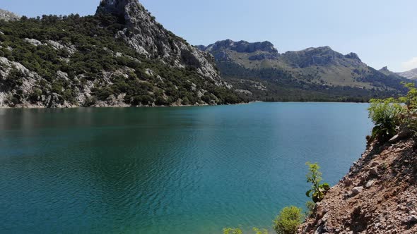Drone flying over the water of Gorg Blau lake in Mallorca, Spain alt