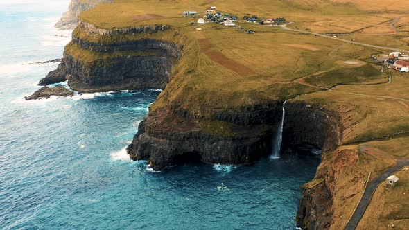 Flying Above Gasadalur Village and Mulafossur Waterfall in the Faroe Islands alt