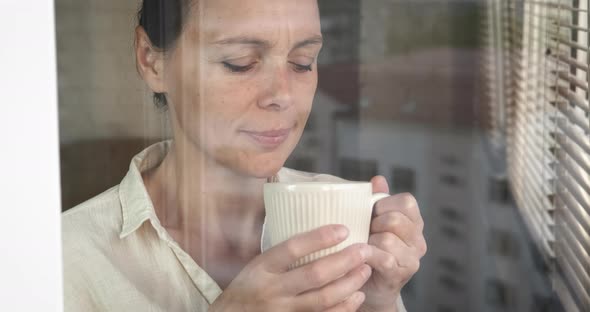 Relaxed Woman with Tea By Window alt