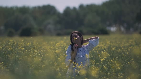 Pretty young woman in the rapeseed field