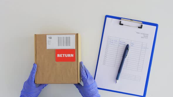 Customer Hands Returning Parcel Box to Mail Worker alt