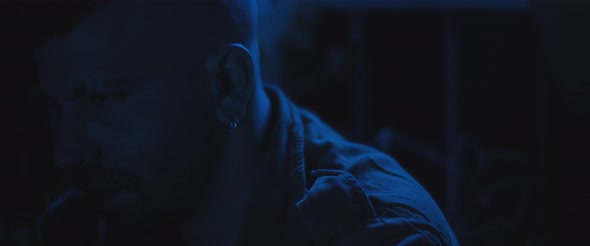 An adult man sitting alone outside at night, dealing with anxiety and post trauma. alt