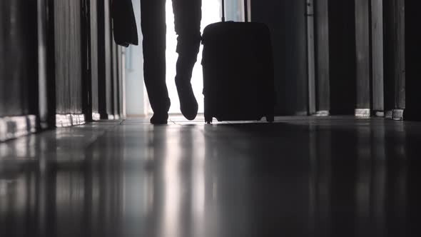 Low Section of Businessman Going with Luggage along Hallway