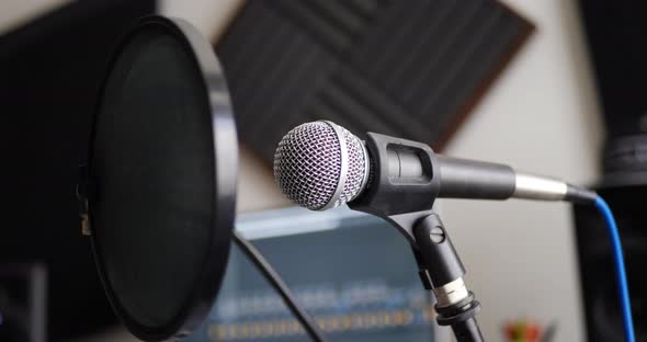 A vocal microphone and pop filter for singing or recording a podcast in a bedroom music studio SLIDE alt