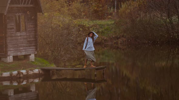Old Wooden House Hut By Lake Among Autumn Forest Woman Walking By Wooden Pier alt