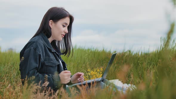 Young Caucasian Teenage Girl Pretty Brunette Beautiful Woman Freelancer Sit Outdoors on Green Lawn alt