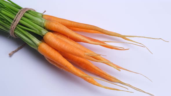 Rotating Bunch of Young Carrots on a White Background