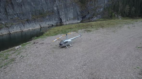The Helicopter Is Standing on the River Starting To Spin the Blades alt