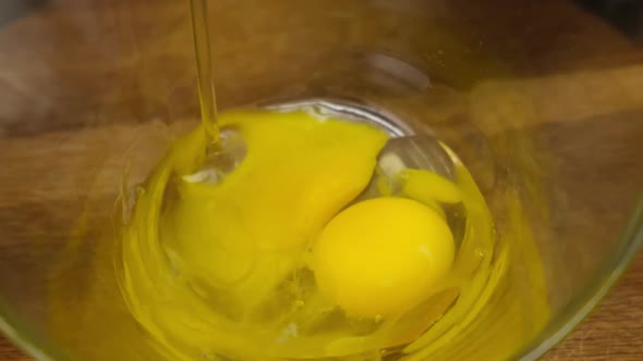 Person preparing homemade omelette mixing with whisk eggs. Close up. HD