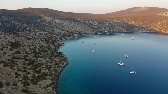 Catamaran and Sail Yachts Anchored at Bay on Deep Blue Sea Water on Sunrise alt