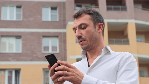 Closeup of a Businessman Working Intently in a Smartphone alt