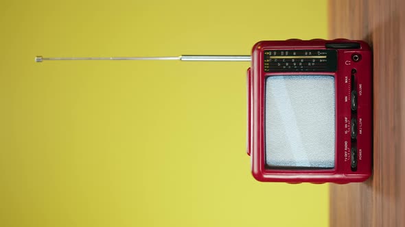 Vertical Video of Small Old Television with Grey Interference Screen on Yellow Background alt