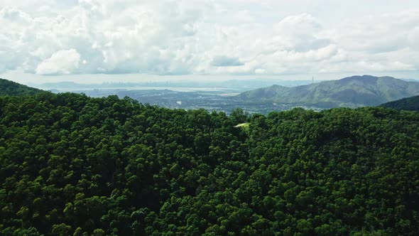 Drone climbing up the mountain revealing the village of Hong Kong near Shek Kong. alt