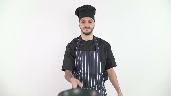 Chef Throwing Vegetables in Kitchen Against White Background, Slow Motion alt