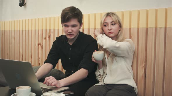 Couple Working on Laptop, Drinking Coffee at Cafe