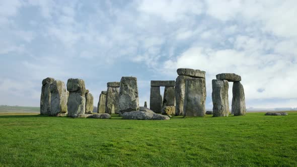 Wide time-lapse of Stonehenge with white clouds alt