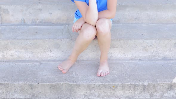 Children's Feet Itch and Stand Barefoot on Cold Concrete Steps