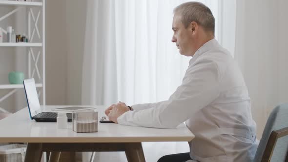 Side View of Confident Male Doctor Talking at Selfie Camera on Laptop. Portrait of Professional alt
