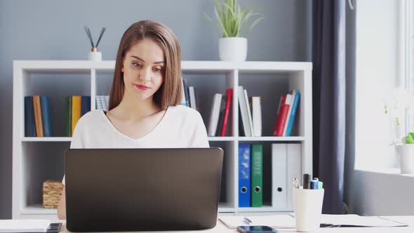 Young Woman Works at Home Office Using Computer. alt