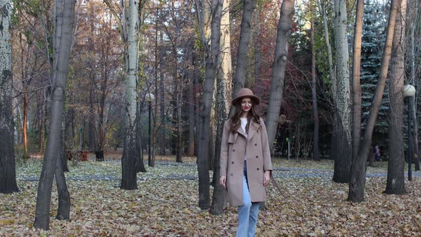 Young Woman Model in Autumn Park with Yellow Foliage Maple Leaves alt
