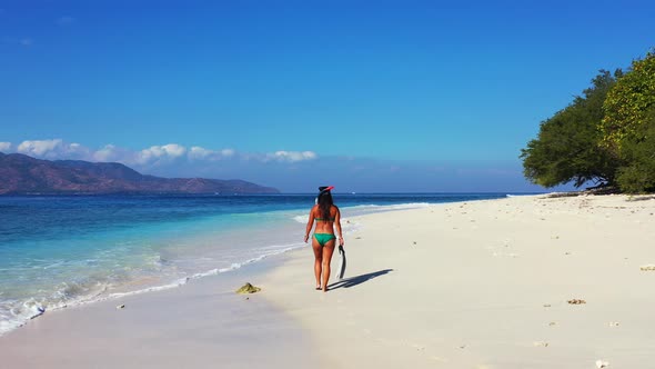 Beautiful fun women relaxing in the sun at the beach on paradise white sand and blue 4K background alt