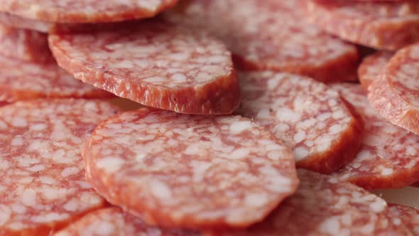 Salami  smaller pieces served on plate food background slow tilt 4K 2160p 30fps UltraHD footage - Ti alt