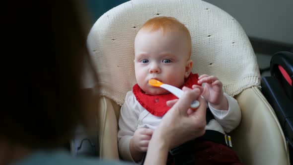 Mother Gives Baby Food From a Spoon