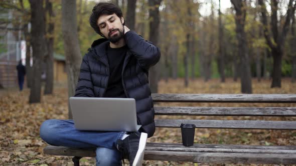 Freelancer Working with a Laptop in the Park Alone Feels Tired alt