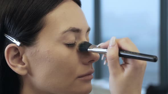 Makeup Artist or Stylist Applies Foundation Powder Brush to the Model's Face