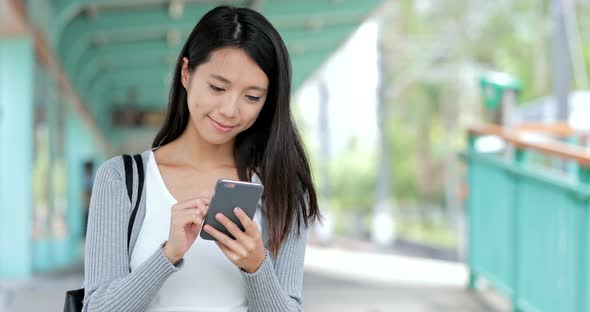 Woman use of cellphone in light rail station of Hong Kong  alt