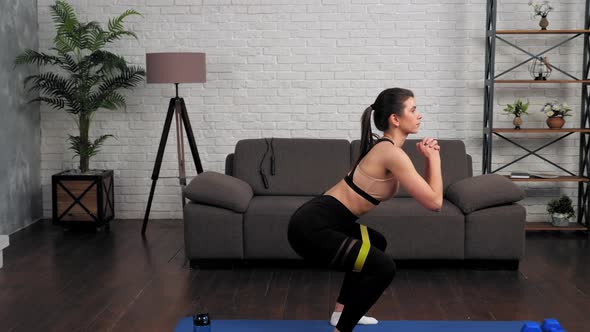Beautiful Athletic Muscular Girl Sportswoman Doing Squat Exercise with Loop Band alt
