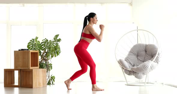 Athletic fit girl doing fitness aerobic exercises for booty in living room. alt