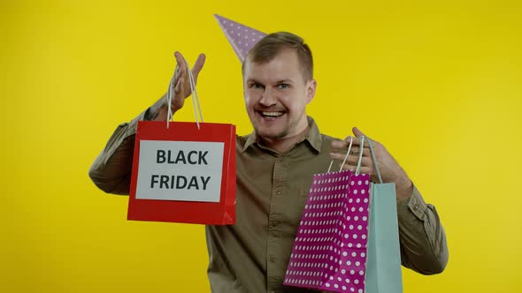 Smiling Man Showing Black Friday Inscription on Shopping Bags, Celebrating, Rejoicing Good Discounts alt