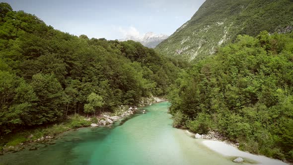 Aerial view of the Soca river surrounded by nature at summer time in Slovenia. alt