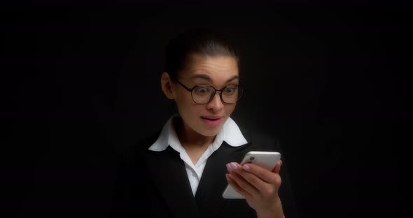 Business Woman is Surprised By the Pleasant News Read in the Mobile Phone