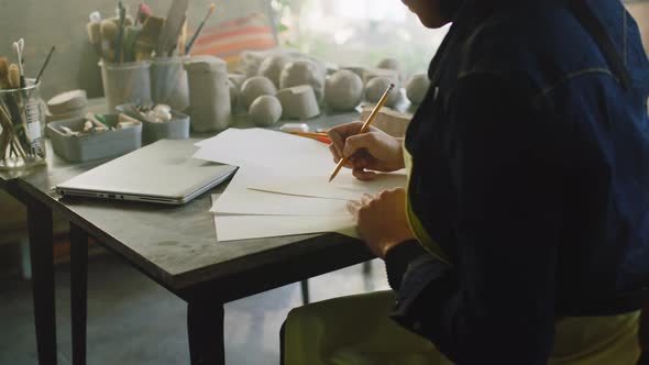 Woman Potter Is Making Sketches