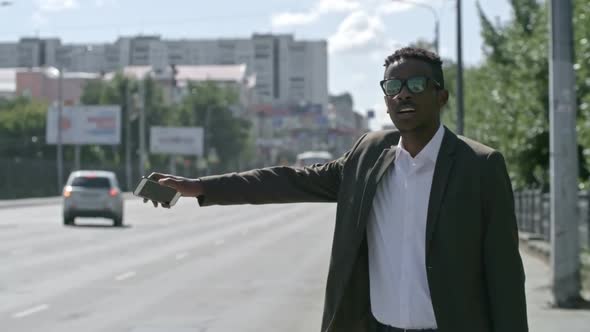 African Businessman Hailing Cab in the Street alt