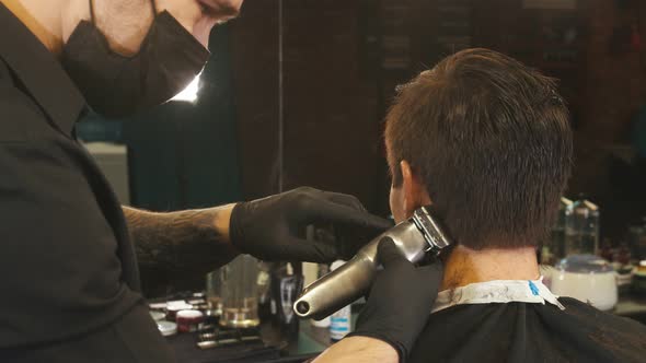Barber Cutting Out the Hair Edging on the Client with a Hair Trimmer alt