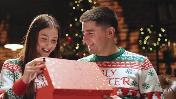 Happy Man is Making Christmas Gift to His Beloved Woman