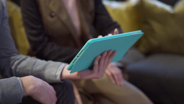Unrecognizable Caucasian Husband and Wife Scrolling Online Catalog Sitting on Comfortable Soft Couch alt