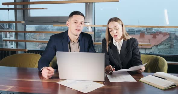 Man and a Woman Discussing Work in the Brightly Lit Modern Office. Concerned Male and Female Working alt
