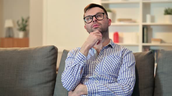 Pensive Young Man Sitting at Home and Thinking  alt
