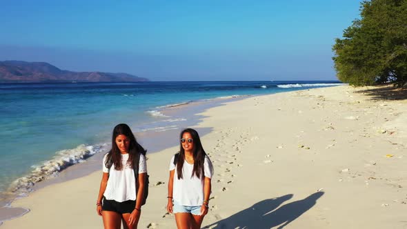 Girls posing on idyllic sea view beach voyage by blue ocean with white sandy background of Gili Air  alt