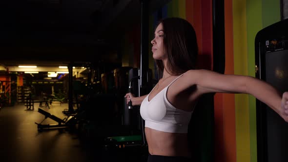 Brunette Girl Performs an Exercise for Muscles Bending and Flexing Her Arms alt