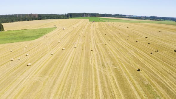 Aerial Drone Shot  a Field with Hay Bales in a Rural Area on a Sunny Day  Flies Across the Field alt