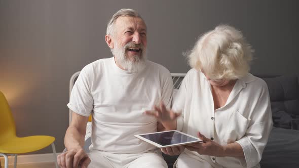 Elderly Caucasian Man and Woman Play Online Games Look at the Screen